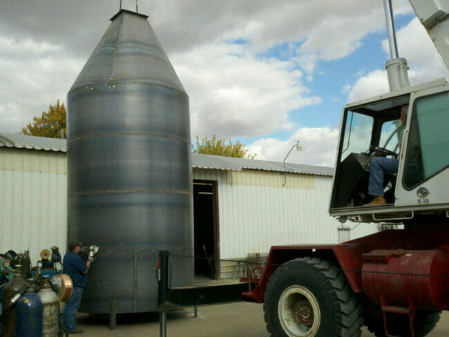 Large steel hopper with square flanged outlet at base